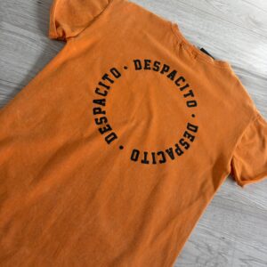 Pomarańczowa koszulka z dłuższym tyłem i napisami