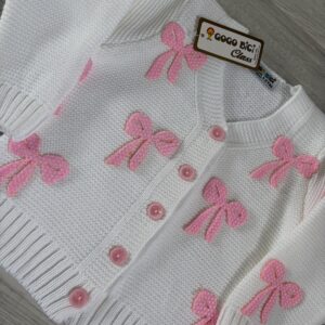Biały sweter dziewczęcy na guziki z różowymi kokardkami